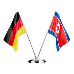 Two table flags isolated on white background 3d illustration, germany and north korea