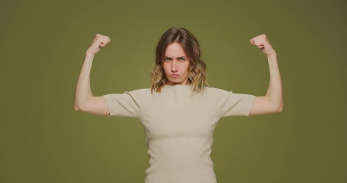 Self proud young woman raising arms showing biceps demonstrate hands muscles, achievements after training