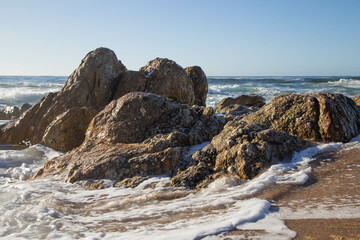 Sea water arriving at Senhora da hora beach, rocks by the sea. In Portugal