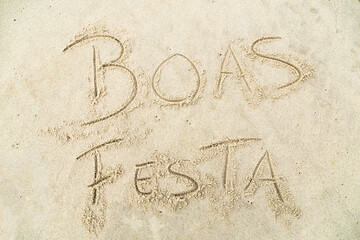 Happy Holidays written in the sand at Furadouro beach in Portugal