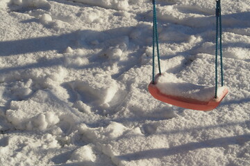 Zaśnieżona huśtawka na tle udeptanego śniegu