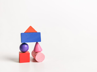 Education concept. Abstract colorful wooden geometric shape against white background.
