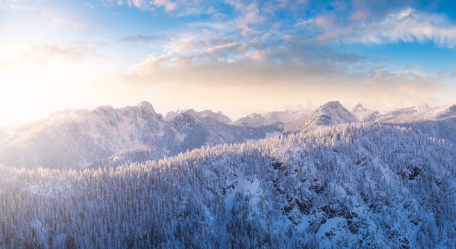 Aerial Panoramic View of Canadian Mountain covered in snow. Colorful Sunset Winter Sky Art Render. Located near Vancouver, British Columbia, Canada. Nature Background Panorama