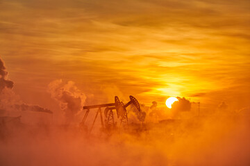 Obraz na płótnie Canvas The pumping units in lakeside sunrise, Daqing oil fields Heilongjiang province, China.