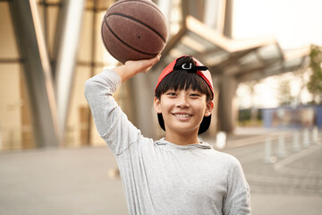 happy asian teenage basketball player