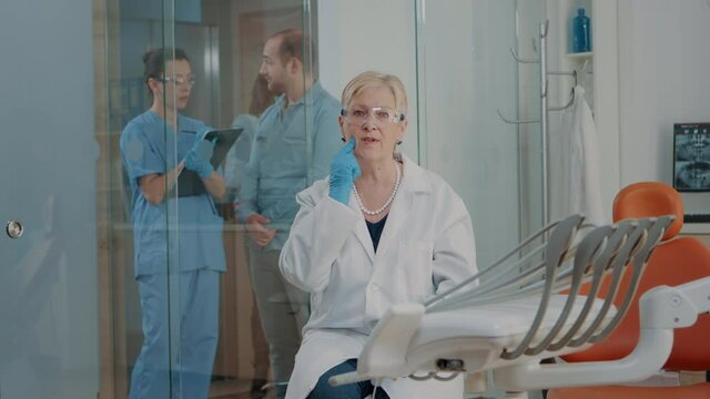 POV of dentistry expert using online video call to give stomatological advice to patient on remote communication. Senior dentist explaining oral care on video teleconference call.