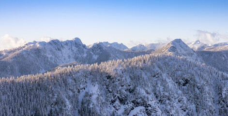 Aerial Panoramic View of Canadian Mountain covered in snow during sunny winter evening. Located near Vancouver, British Columbia, Canada. Nature Background Panorama © edb3_16