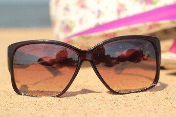 Okulary przeciwsłoneczne na plaży  - obrazy, fototapety, plakaty