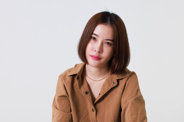 Portrait close up studio cutout shot of Asian stressed depressed worried thoughtful moody short hair female model in long sleeve brown shirt holding hand on forehead have headache on white background