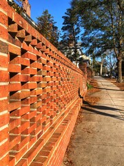 Gorgeous red brick fence, with an open lattice design, seen in the downtown - historic district of Wilmington, North Carolina. The traditional buildings in this area were over 100 years ago.  
