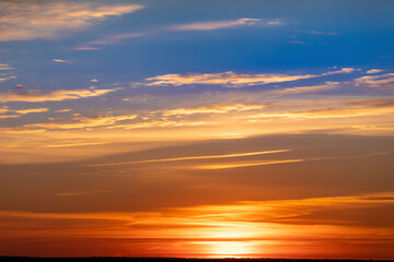 Fototapeta na wymiar Bright warm sun on sky background. Dawn or sunset.