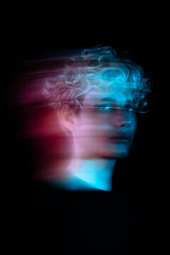 Blurry portrait of blonde young man with uv hair dye in a studio