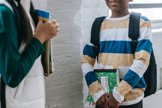 Boy and girl standing and holding school books