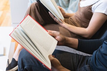 Cropped image of two people reading books