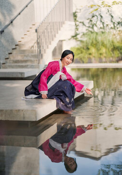 Korean woman in hanbok sitting by poolside