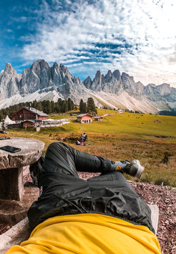Man laying on ground near houses in The Puez-Geisler Nature Park