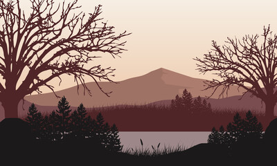 Fototapeta premium Beautiful views of the mountains from the riverbank at dusk with fantastic silhouettes of the surrounding trees.