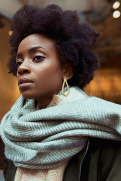 Portrait of Black woman in gray scarf looking away
