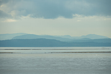 view on the coast with mountain range over the horizon under the thick cloud