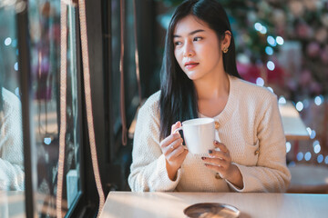 Portrait beautiful young asian woman girl wearing warm clothes enjoys drinking holding of positive the having cup of coffee,milk or chocolate at house home in the living room inside or cafe