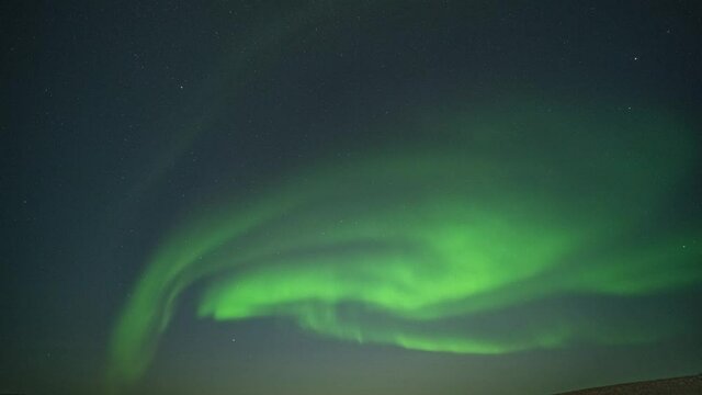 The beautiful dance of the northern lights in the night sky above the fjord.
