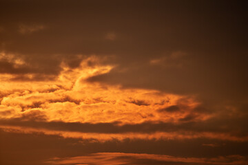 Dramatic sunset, the sun's rays shine through the clouds.