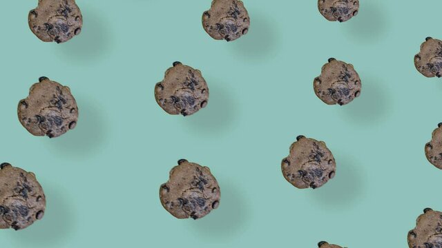 Colorful pattern of fresh chocolate chip cookies. Seamless pattern with cookie. Pop art design. Top view. Realistic animation. 4K video motion