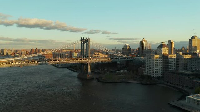 Forwards fly above river. View of heavy traffic on Manhattan Bridge. Slowly moving cars on upper deck and train riding under them. Brooklyn, New York City, USA