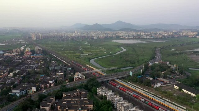 Suburban Scene with Buildings, Railway Station and Bridge in Vasai, Mumbai, India - aerial drone shot