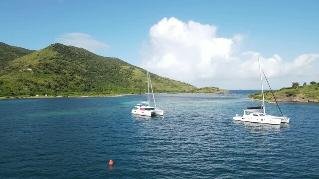 Catamaran yachts in Diamond Cay, near Foxy's Taboo.  Beautiful waters and yachts of the British Virgin Islands.  Sunny, beautiful day
