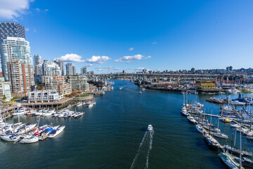 BC, Canada - April 4 2021 : Vancouver city skyline and Granville Island Marina. Granville Bridge.