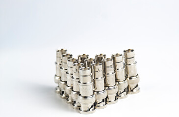 Several BNC attenuators on a white background. RF element for reducing radio signal.