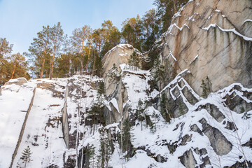 Sheer cliffs and rocks around the Talc quarry in winter in Russia in the town of Sysert, near Yekaterinburg.