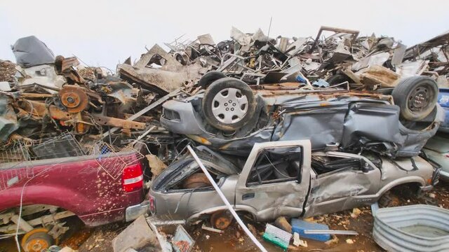 Panning shot of crushed cars and scrap metal