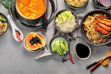 Asian dishes variety on gray background.