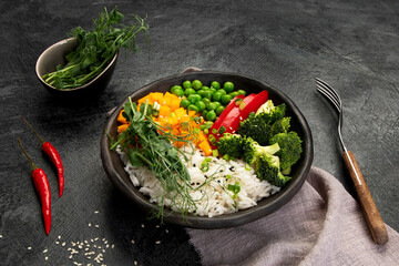 Bowl with rice, broccoli , pumpkin and microgreens.