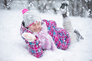 Happy girl throws snow. The child rejoices in winter and the first snow.
