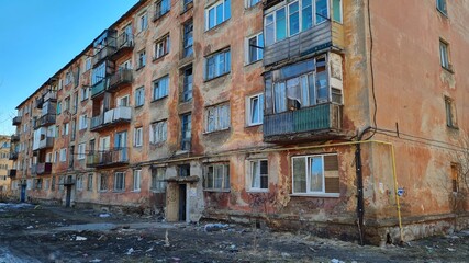 Multi-apartment five-story panel house in a residential area of Khrushchev, built during the USSR. Pink shabby building.