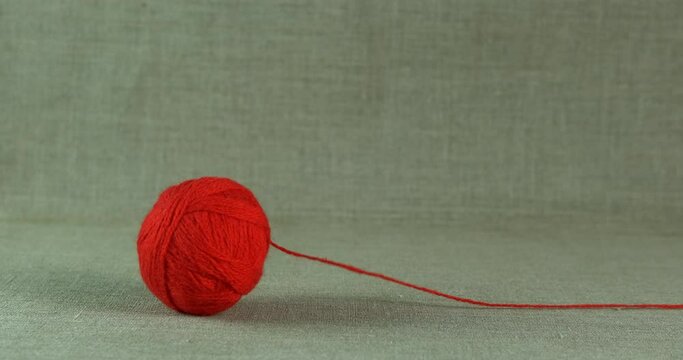 Thread ball on the floor. A view of a red ball from threads rolling on the floor.