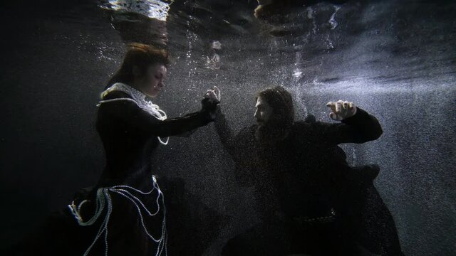mysterious underwater shot of two lovers, floating in depth of sea or ocean, medieval characters