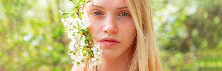 Spring woman face for banner. Beautiful woman portrait close up. Woman on background with flowers...