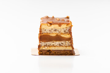Sweet cake with salted caramel with biscuit layers on white background