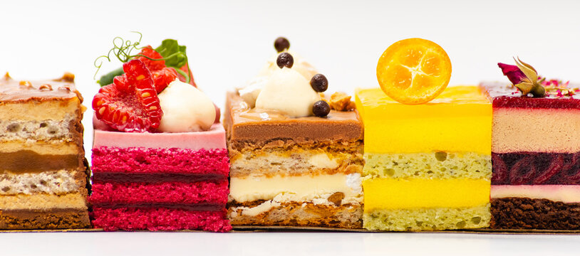 Bright assortment of several different pieces of biscuit fruit cakes on a white background