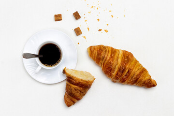 Cup of coffee and brown sugar. Croissants on table.