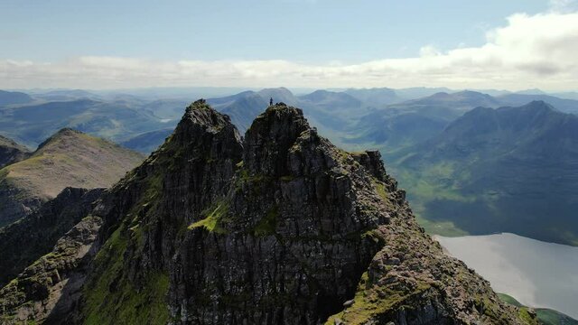 Aerial View Drone Operator On Peak Of An Teallach Mountain In Scottish Highlands. Dolly Back, Establishing Shot