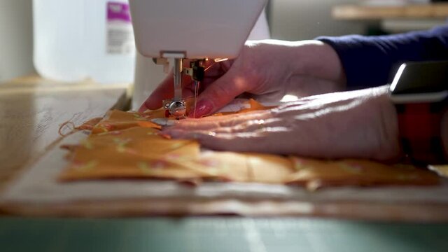 Making a potholder by stitching quilt scraps together in slow motion - ORANGE SCRAPS SERIES