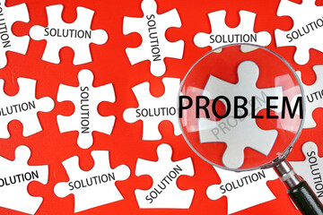 Pieces of jigsaw puzzle with SOLUTION wording and a magnifying glass with PROBLEM wording.