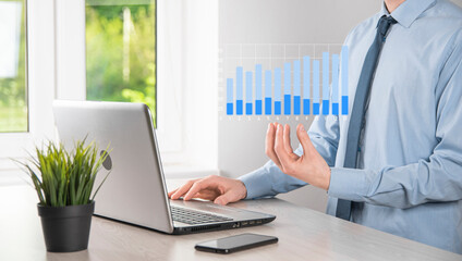Business man holding tablet and showing holographic graphs and stock market statistics gain profits. Concept of growth planning and business strategy. Display of good economy form digital screen.