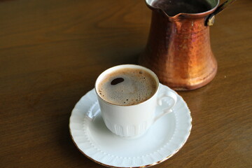 Cup of coffee and cooking pot on the table, Turkish cofffe traditional drink
