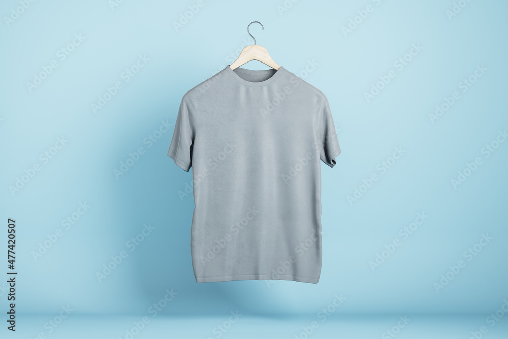 Poster empty gray tshirt hanging on blue wall background. product design and presentation concept. mock up 
